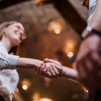 Yrittäjä ja uusi työntekijä kättelevät, toinen hymyilee, kuva alaviistosta.