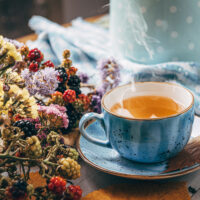 autumn warming tea on a wooden table with autumn tree leaves lyi