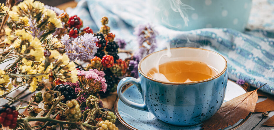 autumn warming tea on a wooden table with autumn tree leaves lyi
