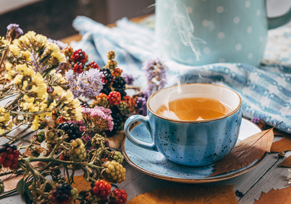 autumn warming tea on a wooden table with autumn tree leaves lyi