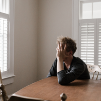 Mies murehtii pöydän äärellä