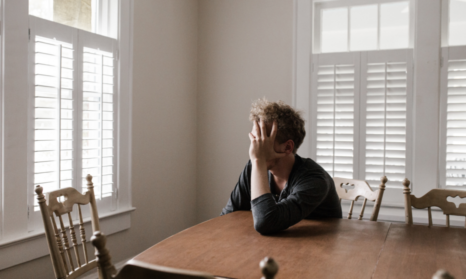 Mies murehtii pöydän äärellä