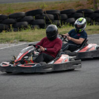 kaksi ihmistä ajaa kartingia